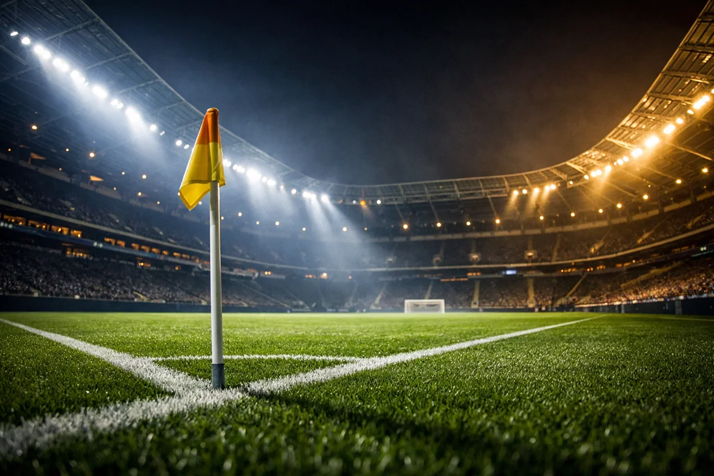 Beleuchtetes Fußballstadion bei Nacht mit grünem Rasen und dramatischer Flutlichtbeleuchtung